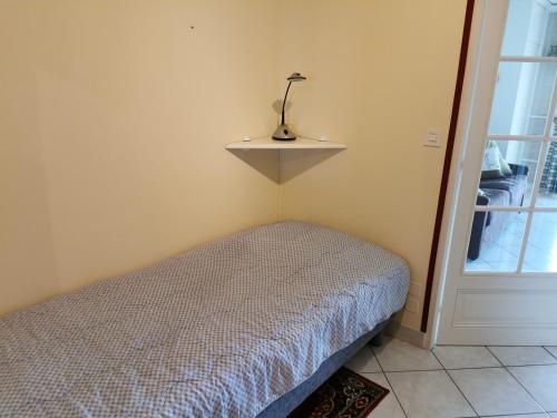 ein Schlafzimmer mit einem Bett und einem Regal an der Wand in der Unterkunft Les Dunes - A 150m de la Grande Plage in Les Sables-dʼOlonne