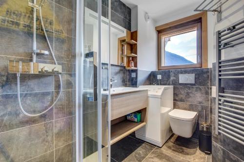une salle de bain avec une douche, un lavabo et des toilettes dans l'établissement Frênes Blancs 105, à Morzine