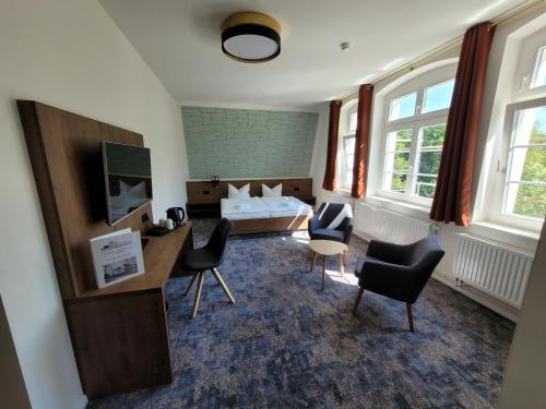 a hotel room with a bed and a desk and chairs at Pension zum Kleistpark in Frankfurt/Oder