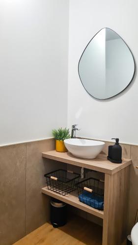 une salle de bain avec un lavabo et un miroir dans l'établissement Magnifique appartement rénové plein centre-ville, à Marmande