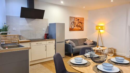 eine Küche und ein Wohnzimmer mit einem Tisch und einem Sofa in der Unterkunft Magnifique appartement rénové plein centre-ville in Marmande