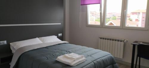 a bedroom with a bed with two towels on it at ALOJAMIENTOS AVICHE 6 in Santander