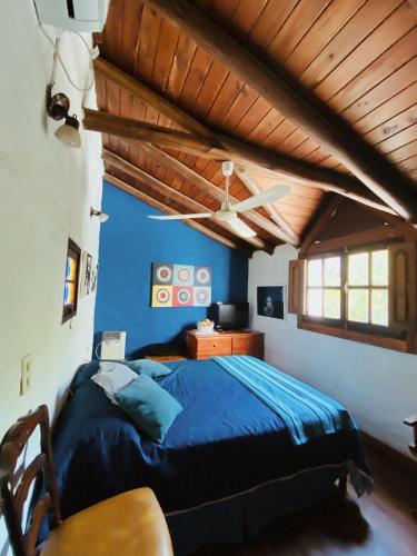 a bedroom with a blue bed and a wooden ceiling at Hospedaje Casa Azul in Villa Allende