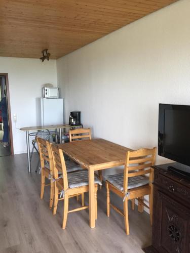 einem hölzernen Esstisch mit Stühlen und einem TV in der Unterkunft On the hill in Sasbachwalden