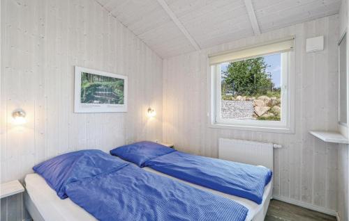 1 dormitorio con cama con sábanas azules y ventana en St, Andreasberg, Haus 37, en Sankt Andreasberg