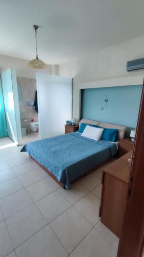 a bedroom with a bed with a blue comforter at Villa Katerina in Ialysos