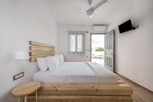 Schlafzimmer mit einem großen Bett mit einem Kopfteil aus Holz in der Unterkunft Annarita in Adamas