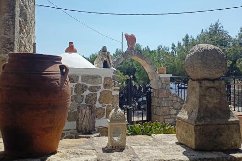 a group of vases sitting next to a fence at Traditional Creta stone house in serenity village in Vitsiliá