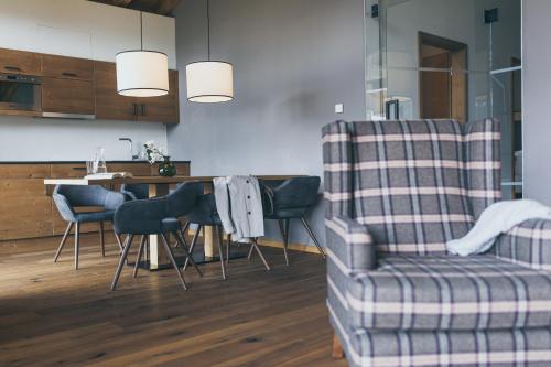a living room with a couch and a table and a chair at PUR Suites & Chalets in Lermoos