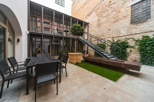 eine Terrasse mit einem Tisch und Stühlen neben einem Gebäude in der Unterkunft r12 Apartments in Győr