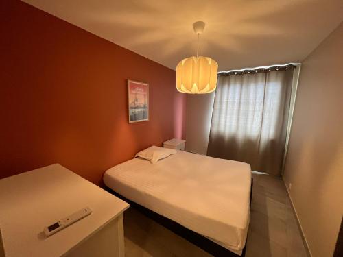 une petite chambre avec deux lits et une table dans l'établissement Gites Terres De Provence, à Bourg-Saint-Andéol