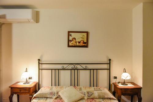 1 dormitorio con 1 cama con 2 mesitas de noche y 2 lámparas en Appartamento Mughetto con A/C, en Porto San Paolo