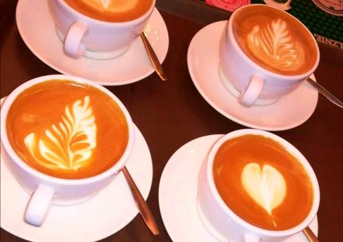 three cups of coffee on plates on a table at Mevo Apartament - Apartamenty 4 -6 osobowe in Polańczyk