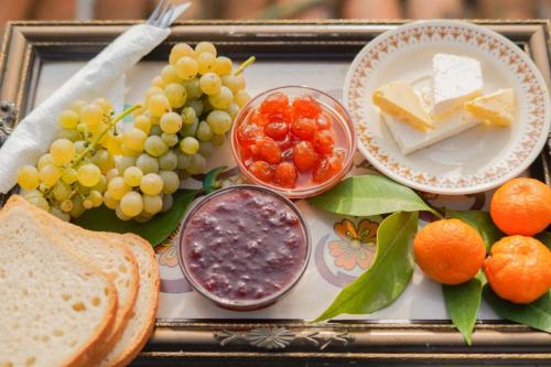 a tray of food with grapes cheese and bread at Tomor Shehu Guest House in Berat