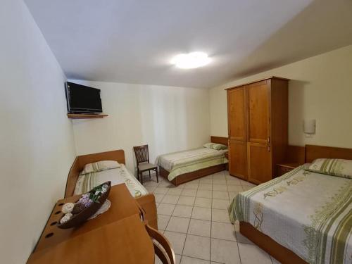 a hotel room with two beds and a tv at Guest house Kočanija in Ilirska Bistrica