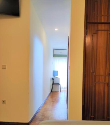 un corridoio con una porta e una sedia in una stanza di Hotel Peninsular a Caldelas