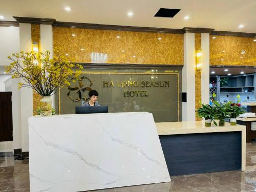 a woman sitting at a desk in a lobby at Ha Long Seasun Hotel in Ha Long