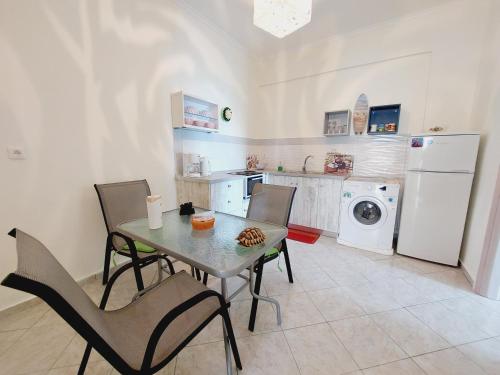 アギオス・ゲオルギオスにあるLeta apartmentsのキッチン(テーブル、椅子、洗濯機付)