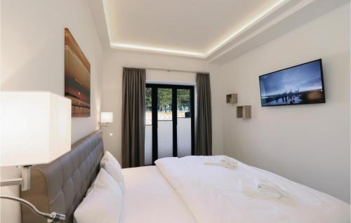 ein Hotelzimmer mit einem Bett und einem TV an der Wand in der Unterkunft Moon in Binz