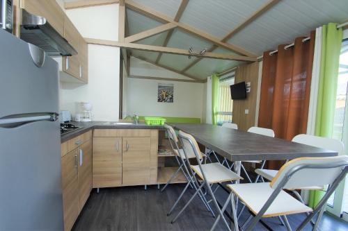 una cucina con tavolo e sedie in una stanza di Oasis des Garrigues a Vogüé