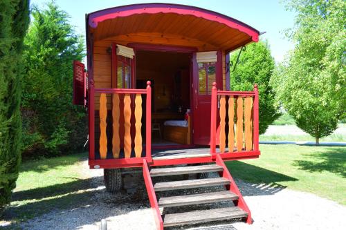 a red out house with a staircase in a yard at Domaine des Vignères in Saint-Maurice-de-Tavernole