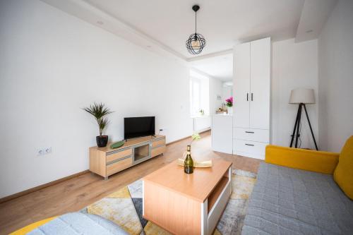 a living room with a tv and a couch and a table at Modern Studio Apartment in the Old Town in Sarajevo