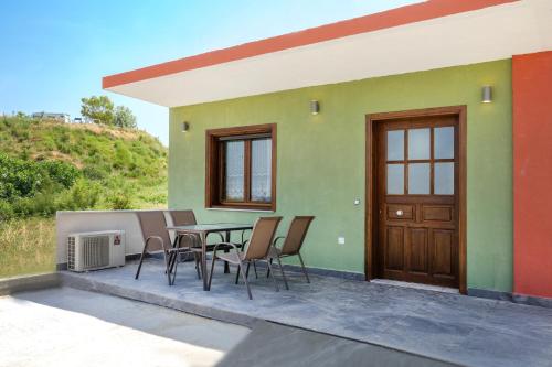 a house with a table and chairs on a patio at DANAI HOUSE 3 in Nea Roda