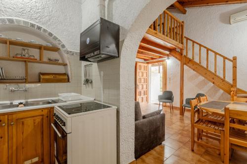 a kitchen with a stove and a dining room with a table at Sophia's maisonette 1 in Stoupa