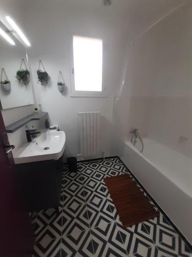 a bathroom with a sink and a mirror and a tub at Villa " Les Bambous " , Jardin , Terrasse , Climatisation , Wifi , Parking in Avignon