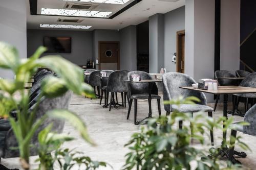 uma fila de mesas e cadeiras numa sala com plantas em Hakcan Hotel em Esmirna