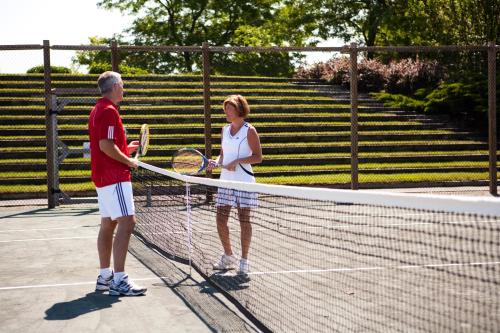 a man and a woman standing on a tennis court at The Villages at Ocean Edge Resort & Golf Club in Brewster
