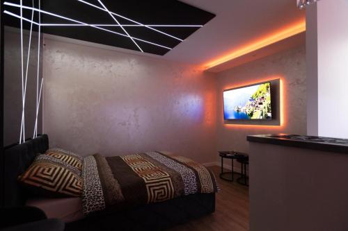 a bedroom with a bed and a tv on the wall at Foča Apartmani "Story Lux" in Foča