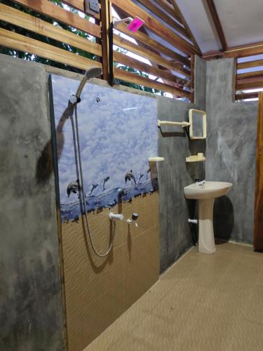 a bathroom with a shower and a toilet and a sink at Thambili cabanas whisky point in Arugam Bay