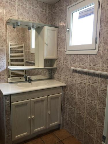 een badkamer met een wastafel, een spiegel en een raam bij Chez Anidé in Cannet