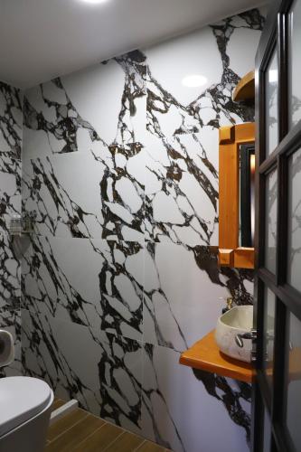 Un baño con una pared de mármol blanco y negro. en Vila Darla, en Berat