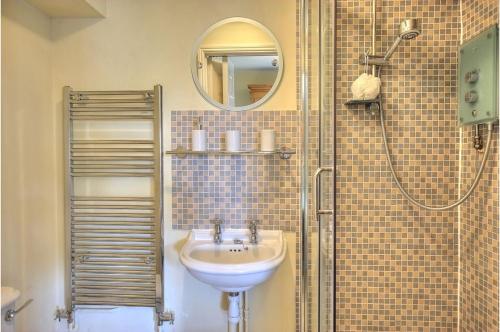 a bathroom with a sink and a shower at Waterside, Elmham Watermill, Norfolk in North Elmham