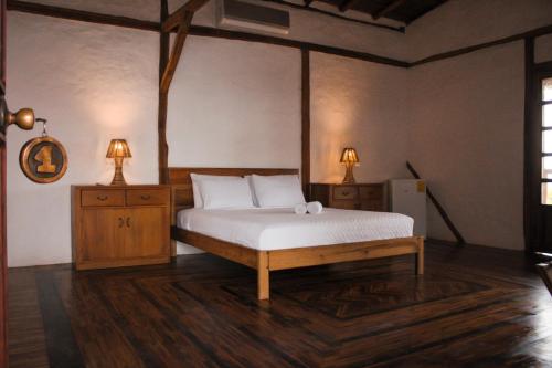 a bedroom with a bed with two night stands and two lamps at Ayampe Guest House in Ayampe