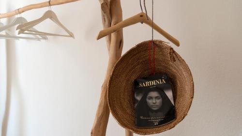 a picture of a book in a hat hanging on a wall at Le Stanze di Patika in Tortolì