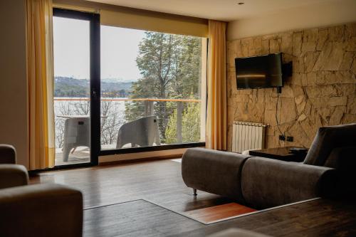 - un salon avec un canapé et une grande fenêtre dans l'établissement Amarras, à Villa Pehuenia