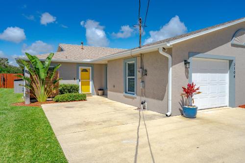 uma casa com uma porta amarela e uma entrada em Unique Balinese Home with Fire Pit and Private Fenced Yard! 30 Seconds to the Sand! em New Smyrna Beach