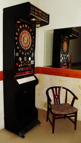 a game room with a chair and a dart board at Tündérszikla Panzió in Pilisjászfalu