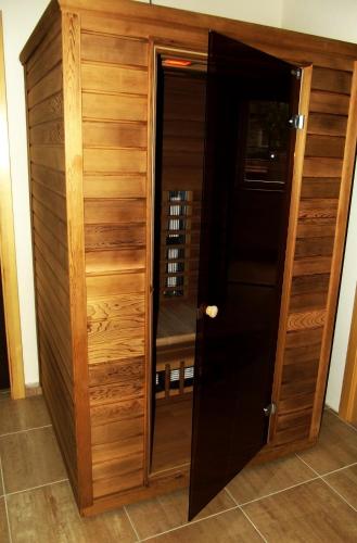 a wooden cabinet with a door in a room at Tündérszikla Panzió in Pilisjászfalu