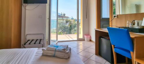 a bag sitting on a bed in a room with a kitchen at Hotel Casa Marinella in Malcesine