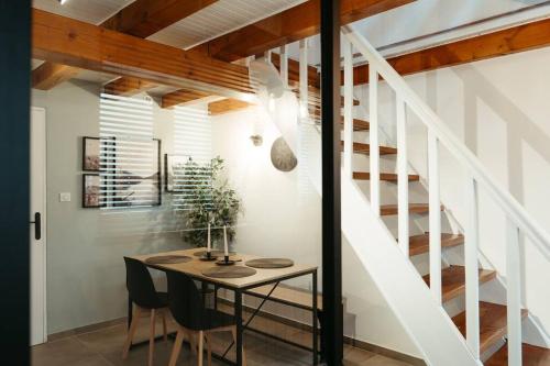 a dining room with a table and a staircase at La Villetta SPA -logement atypique in Mulhouse