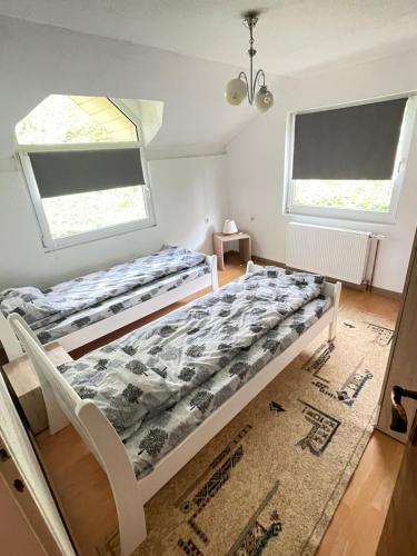a bed in a room with two windows at Neretva View in Počitelj
