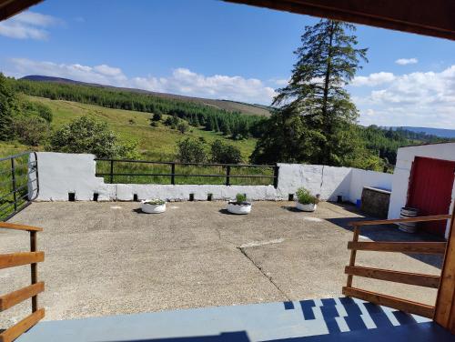 a view of a patio with a fence and trees at Maggies Cottage in Manorhamilton