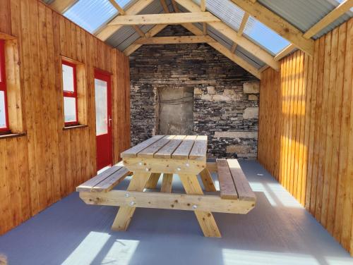 a picnic table in a room with a brick wall at Maggies Cottage in Manorhamilton