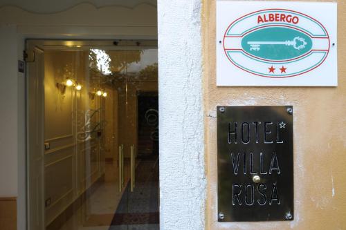 a sign on the side of a building with a hotel willka at Hotel Villa Rosa in Venice