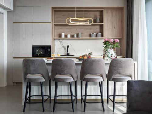 a kitchen with a table with four chairs and a counter at Beyond Breathtaking Modern Residence Sir. Perfect in Dubrovnik