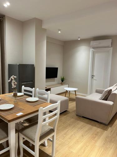 uma sala de estar com uma mesa e um sofá em Costa Adriatica Apartments em Durrës